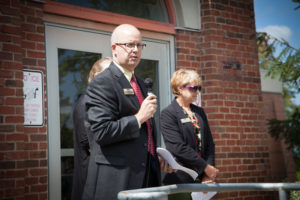 Steve Minkler standing in front of Chapman Hall speaking in microphone
