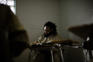 Prison student at desk taking notes