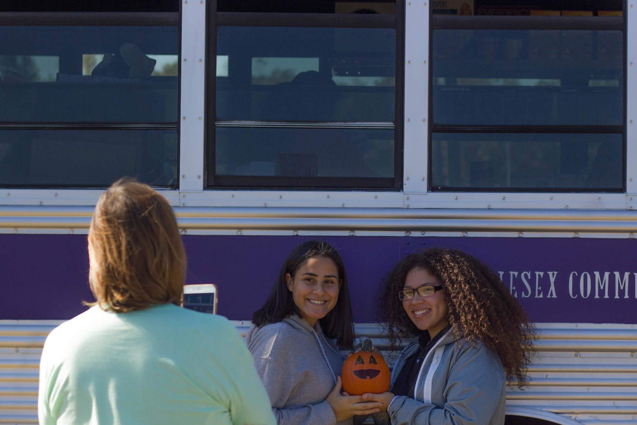students pose in front of food bus