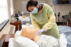 Patient Care Technician practicing on dummy