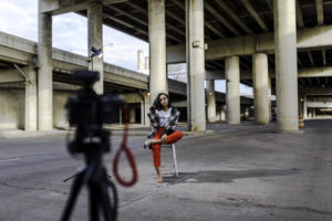model being photographed outside under bridge