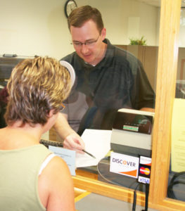 man in business office helping woman with forms