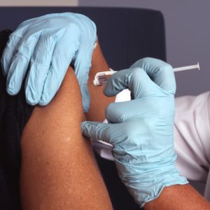 Medical professional administers vaccine in patient's arm