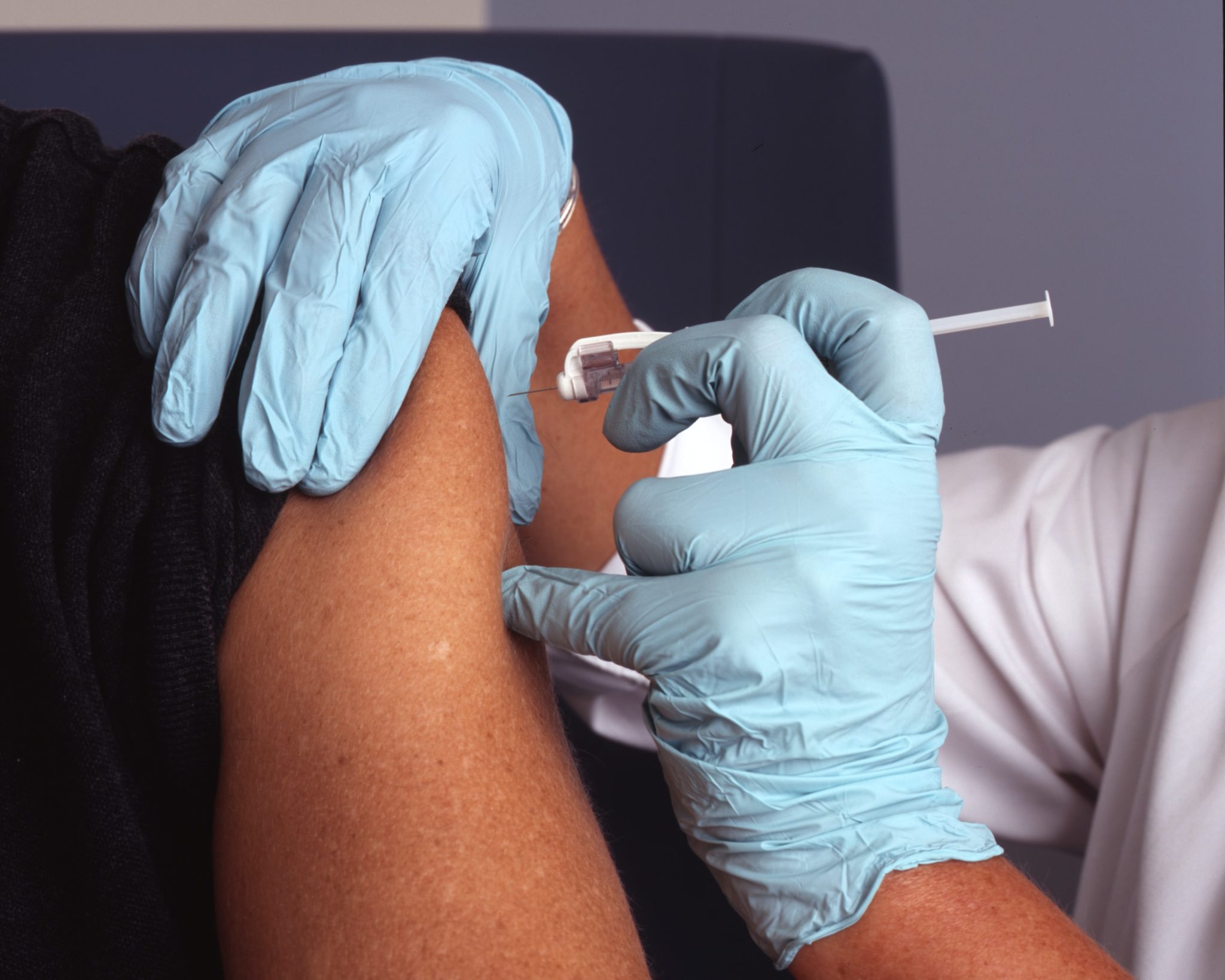 Medical professional administers vaccine in patient's arm